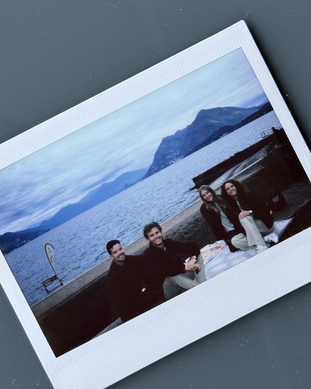 A polaroid of Bodhi, Tess and friends with pizza by Lago Maggiore