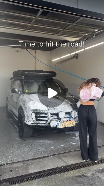 Tess washing the foam-covered Cayenne at a car wash: "Time to hit the road!"