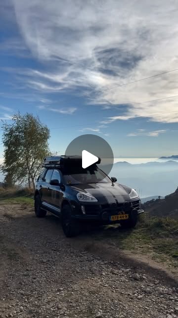 The Cayenne with roof tent on a gravel track high above the clouds