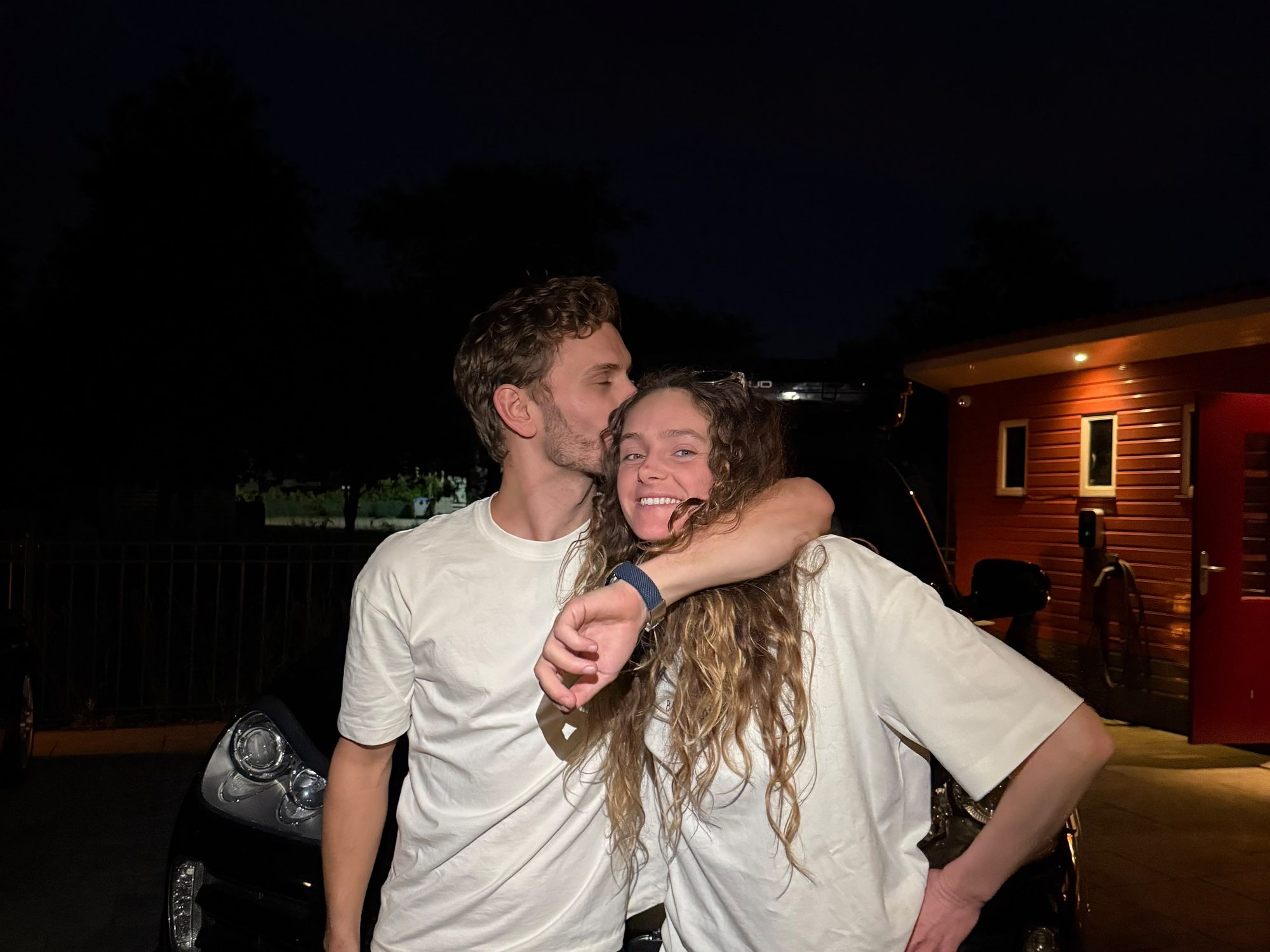 Bodhi kissing Tess on the head in front of the Cayenne, the night before we left