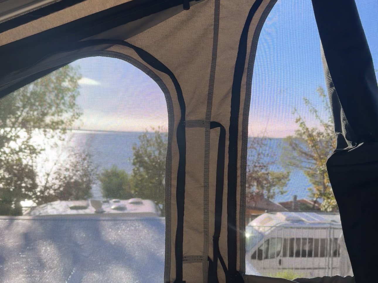 Waking up in the roof tent with a view of Lake Garda through the mesh windows