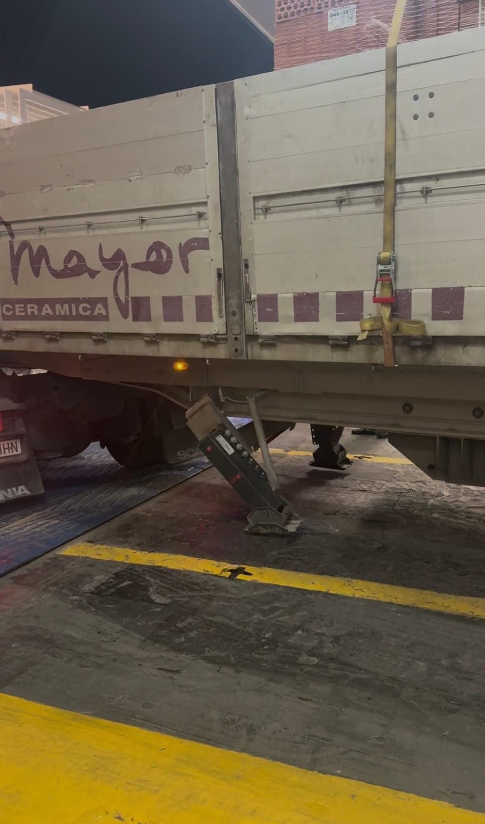 A bent landing leg hanging askew under a lorry's trailer on the ferry's car deck